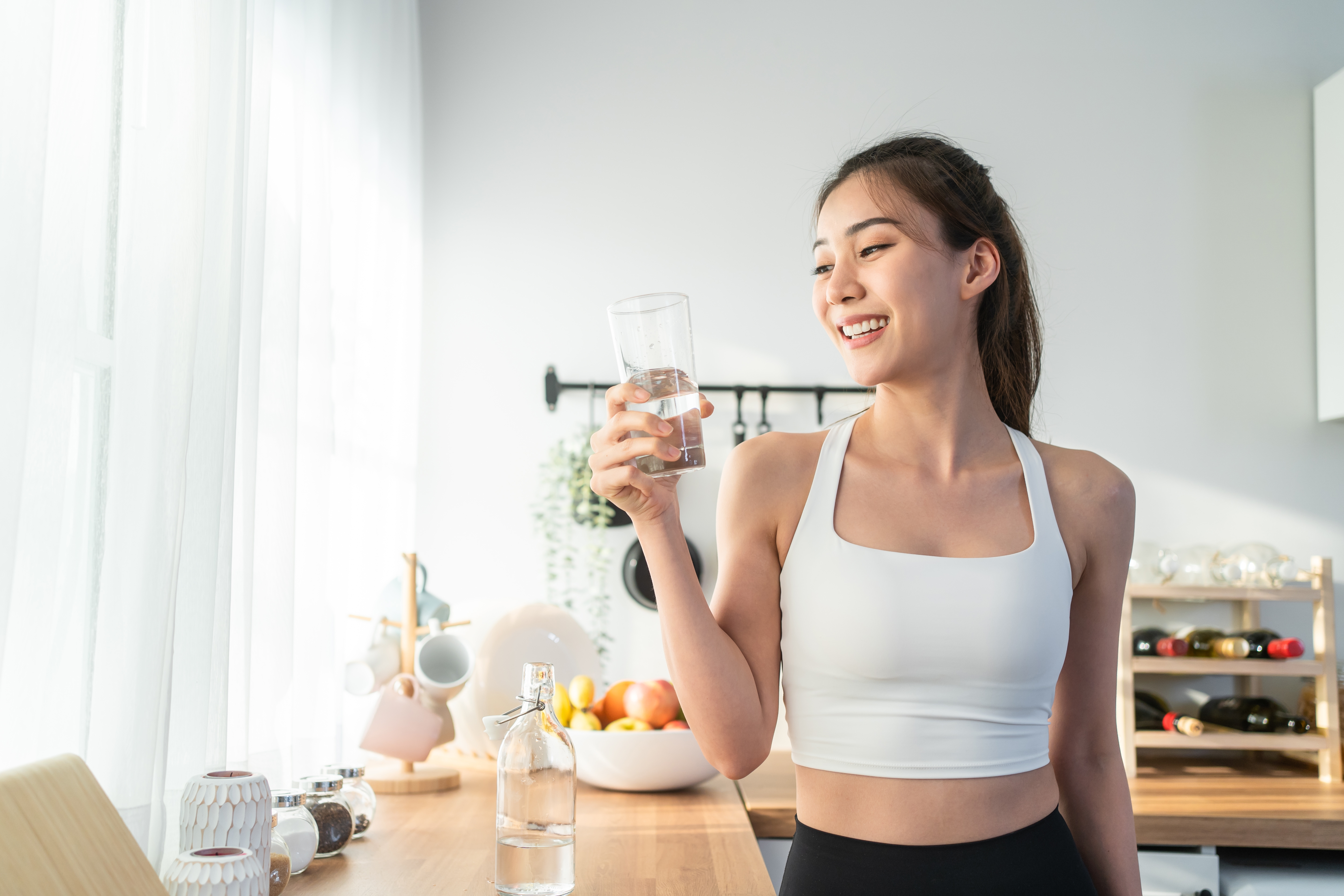 a woman drinking water with yoga suite